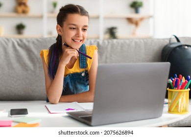 Elearning, Distance Course. Smiling Teen Girl Studying At Home Sitting On Sofa Watching Online Webinar Webcast Class, Female Student Looking At Laptop Screen, Video Calling Remote Teacher Using Pc