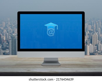 E-learning Flat Icon On Desktop Modern Computer Monitor Screen On Wooden Table Over Office Building Tower And Skyscraper In City, Business Study Online Concept