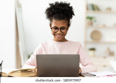 E-Learning. Happy African Teen Girl Studying At Laptop Computer Learning At Home, Wearing Eyeglasses - Powered by Shutterstock