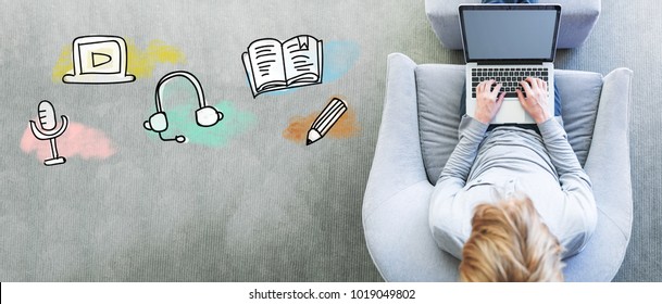 E-Learning with man using a laptop in a modern gray chair - Shutterstock ID 1019049802