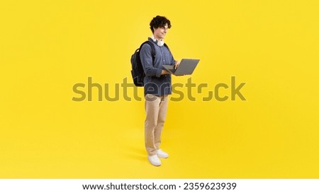 E-Learning, Online Study Offer. Young Student Guy Using Laptop Learning And Browsing Internet, Posing With Computer Advertising College Website Standing On Yellow Background. Panorama
