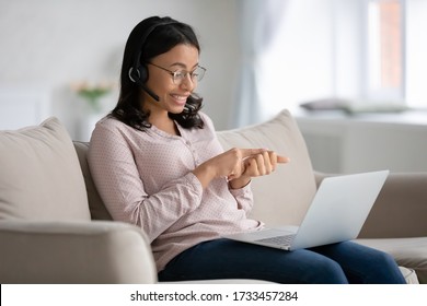 E-learning With Teacher Or Due Covid-19 Coronavirus Company Staff Employees Working From Home Using Videoconferencing App Concept. African Woman Wear Headset Sit On Sofa Put Pc On Lap Talks Distantly