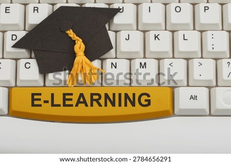 E-learning text with a grad cap on white computer keyboard for online degrees and remote learning