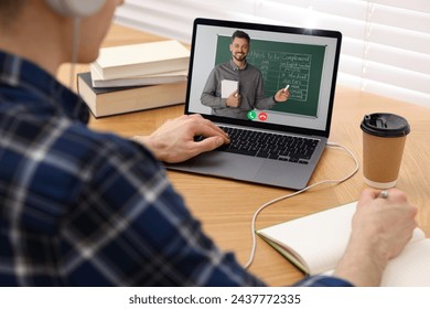 E-learning. Young man having online lesson with teacher via laptop at home, closeup