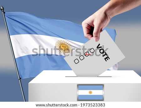 Elections in the Argentina. The hand that puts the game in the ballot box. Argentina flags in the background. Country flag election.