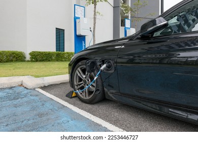 Electric automobile loading, plugged into charging station. - Shutterstock ID 2253446727