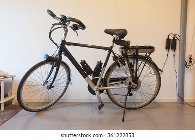 Electric Bicycle In A Garage, Charging The Battery