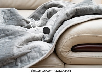 electric blanket with controller on a sofa - Shutterstock ID 2212705061