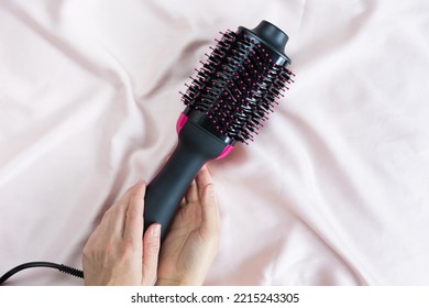 Secador de pelo de cepillo de soplo eléctrico sobre fondo rosa
