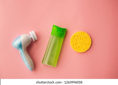 electric brush cleanser and gel for cleansing the face and a face sponge on a pink background. Facial care. Cosmetic device. Deep skin cleansing. selective focus.