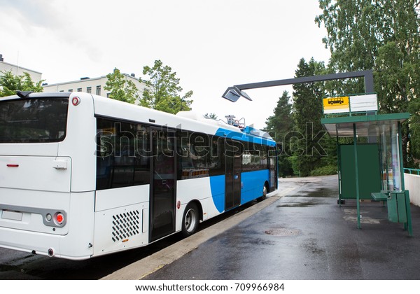 Electric bus at a stop is charged by wireless\
induction charging