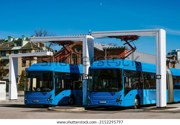 Electric buses are in the parking lot on a\
charge. Eco-friendly urban public\
transport