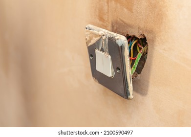 Electric cable exposed inside electrical switcher on wall during house renovation.