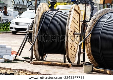 Electric cable on a wooden reel located at a construction site. Construction and installation of electrical networks on a city street. Close-up