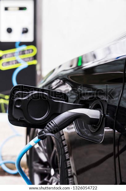 Electric cable is providing energy for charging\
electric car at the\
station.