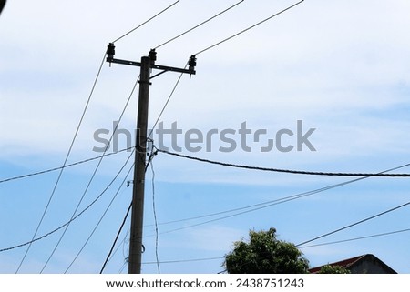 Electric cables are messy on electricity poles. Blue sky negative space home telephone cables with messy and neatly arranged pole cables.