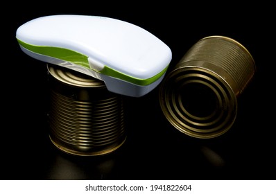 Electric can opener and canned good isolated on black background