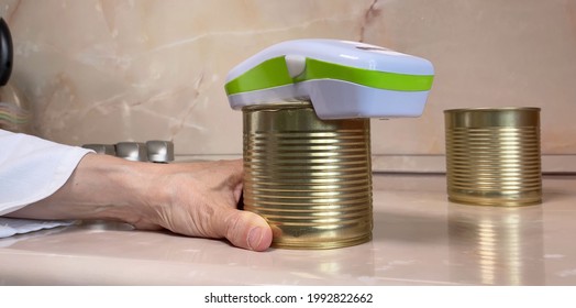 Electric Can Opener And Canned Goods On Kitchen Table