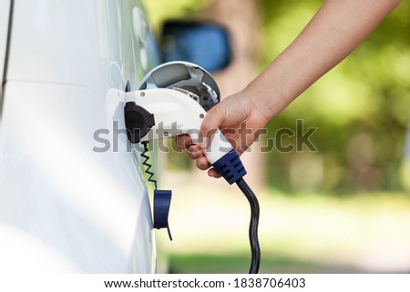 Electric car battery charging at charge station in the nature
