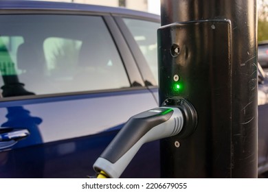 Electric car being charged from a charging point on a street light post. - Shutterstock ID 2206679055