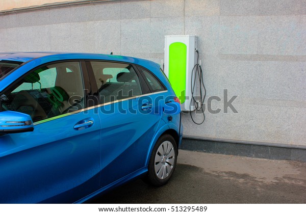 Electric Car Being Charged. Electric car\
charging station. Close up of the power supply plugged into an\
electric car being\
charged.