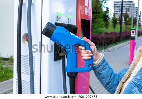 Electric car charge. Power cable pump plug in eco\
green energy hybrid vehicle on future charger station. Recharge\
fuel technology with cable to power battery. Ecofriendly\
sustainable energy\
concept