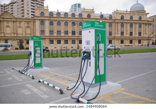 Electric car charger . The panel with two pistols\
for charging electric vehicles close-up. Electric charge station\
for eco car with charger to recharge electricity into vehicle on\
city street outdoor
