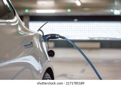 Electric Car Charger Plugged In A Vehicle Socket In The Parking Garage