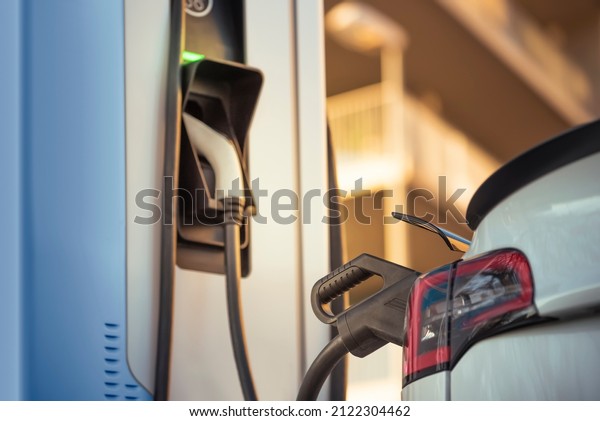 Electric car charging the battery at the charging\
station on the street