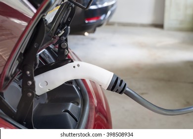 Electric Car Charging In A House Garage With Home Charger, Copy Space.