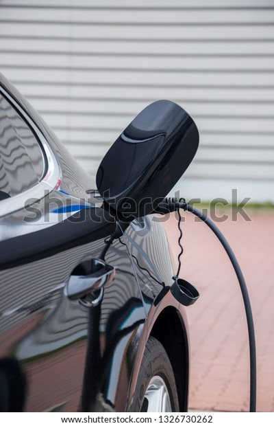 Electric car  charging on charge station –\
electro mobility environment friendly \
