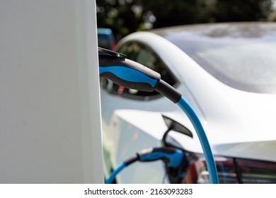 Electric Car Charging At Plug In Charge Station In A Public Car Park In Suffolk, UK