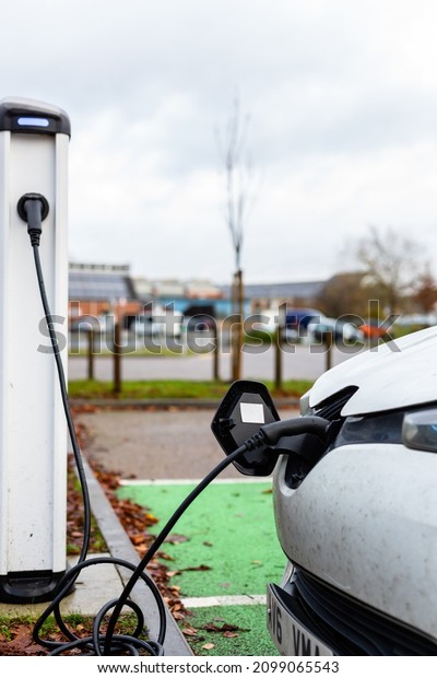 Electric car charging at plug in charge\
station in a public car park in Suffolk,\
UK