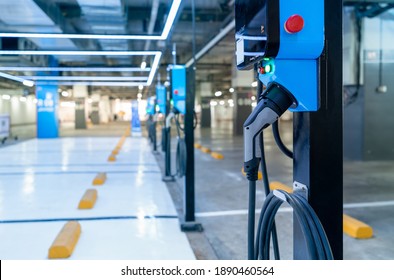 Electric car charging station for charge EV battery. Plug for vehicle with electric engine. EV charger. Clean energy. Charging point at car parking lot. Green power. Future transport technology. - Shutterstock ID 1890460564
