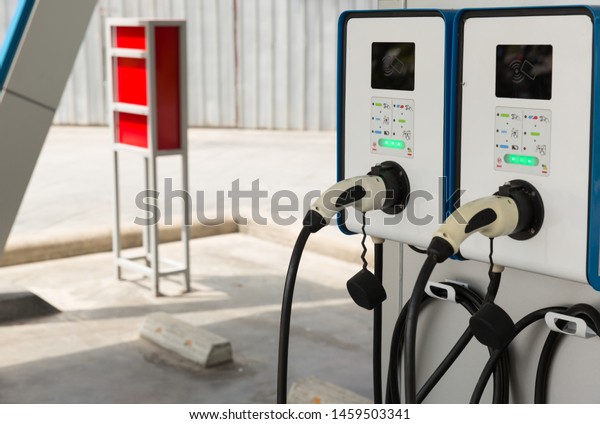 Electric car charging station. Hybrid car\
Electric charger station in the Car Park. Electric car charging on\
parking and charging\
station.
