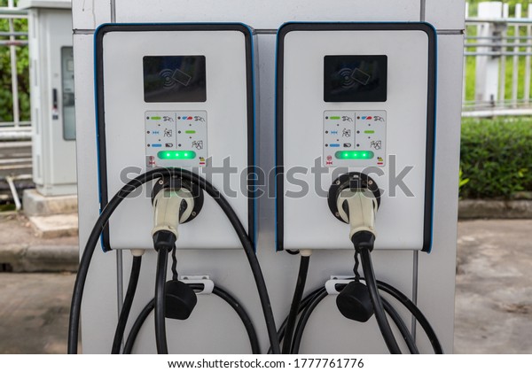 Electric car charging station. Hybrid car\
Electric charger station in the Car Park. Electric car charging on\
parking and charging\
station.