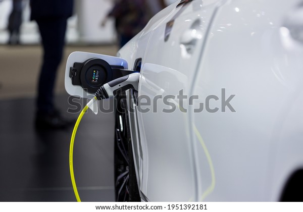 Electric car charging\
station. Hybrid car Electric charger station in the Car Park.\
Electric car charging on parking and charging station. Electric\
socket. Transportation\
EV