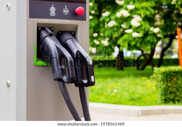 Electric car charging\
stations in the background of the park area. Column for charging\
electric vehicles.
