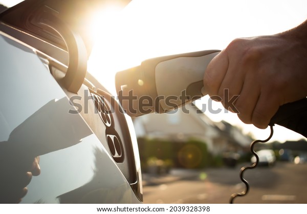 Electric car\
charging with sun in the\
background