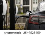 Electric car charging. Electric vehicle EV hybrid car with charging connector. Power cable pump plug in charging power to electric vehicle EV car. Eco energy. Electric car during charging.