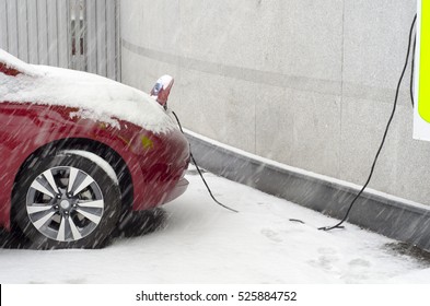 Electric Car At Charging In Winter