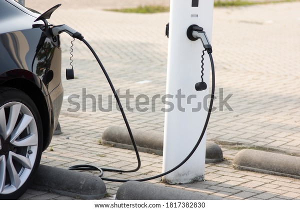 Electric car connected to charge station for\
charging the battery