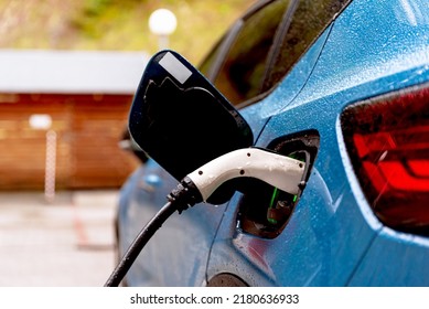 Electric car connected to charger, close up. Charging battery at EV charging station. Green energy, zero emission and eco friendly car concept