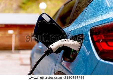 Electric car connected to charger, close up. Charging battery at EV charging station. Green energy, zero emission and eco friendly car concept
