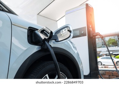 Electric car in EV charging station, concept of green energy and eco power produced from sustainable source to supply to charger station in order to reduce CO2 emission. - Shutterstock ID 2286849703
