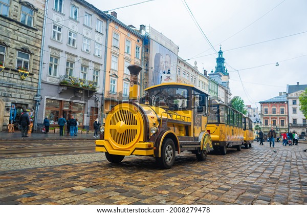 An electric car in the form of a steam\
locomotive with carriages. Excursion car in the old city of Europe.\
Lviv, Ukraine - 05.15.2019