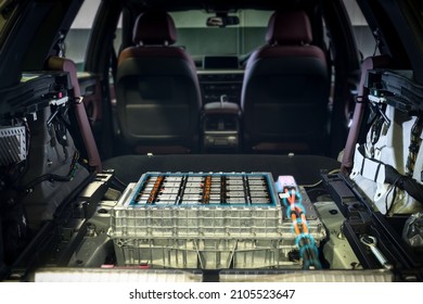 Electric car lithium battery pack and power connections on EV car background.	
