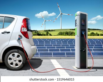 Electric car on charging spot with solar panels and wind energy in front of landscape