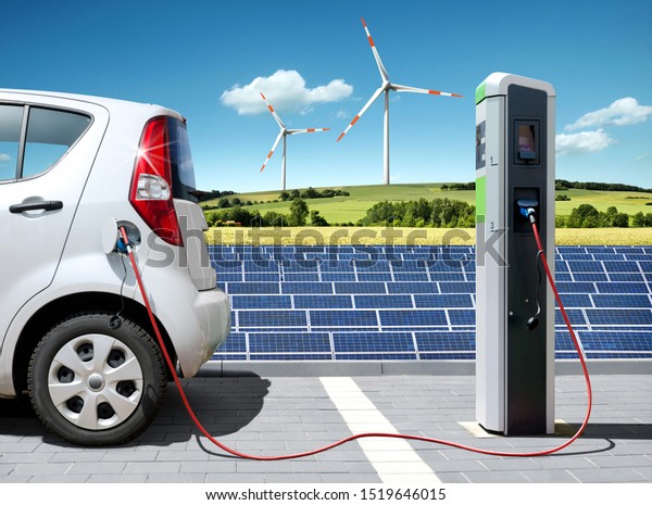 Electric car on charging spot with solar panels\
and wind energy in front of\
landscape