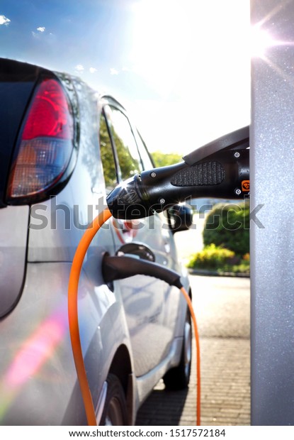 Electric Car on a charging station with back and\
light plug detail, electric\
mobility